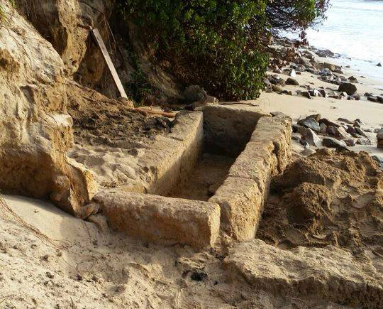 Chia, la violenta mareggiata e il vento di scirocco riportano alla luce un’antica tomba punica lungo la spiaggia de Sa Colonia