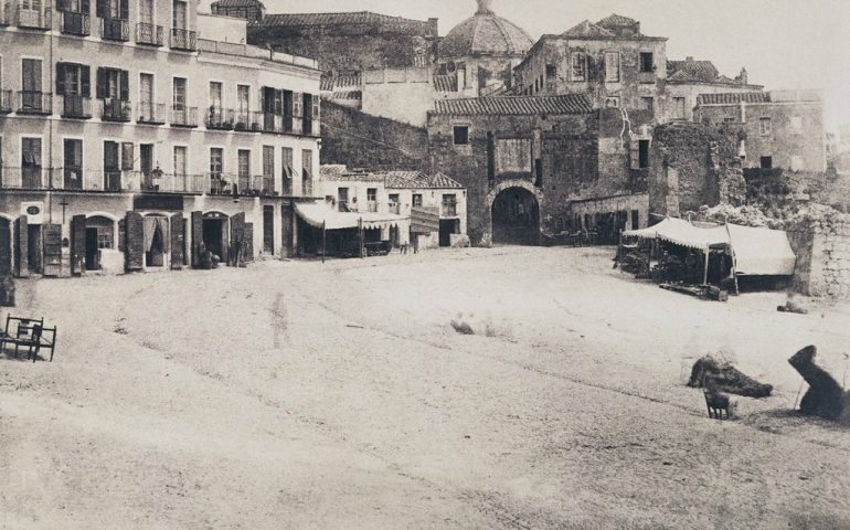 La Cagliari che non c’è più. Pieno Ottocento, piazza Yenne: ci sono ancora le mura della Marina, la porta di Stampace e manca la statua di Carlo Felice