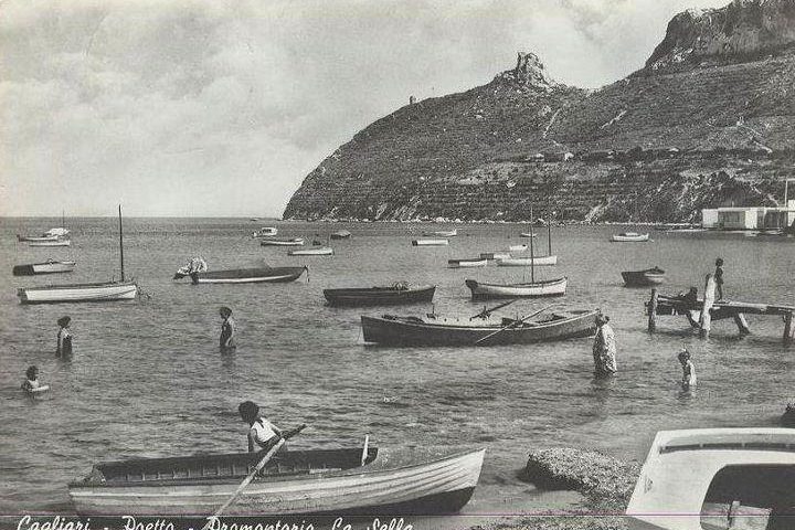 La Cagliari che non c’è più, Poetto, 1960: nessun uomo tatuato, né bicipiti al vento, in acqua solo le barche dei pescatori e qualche bagnante