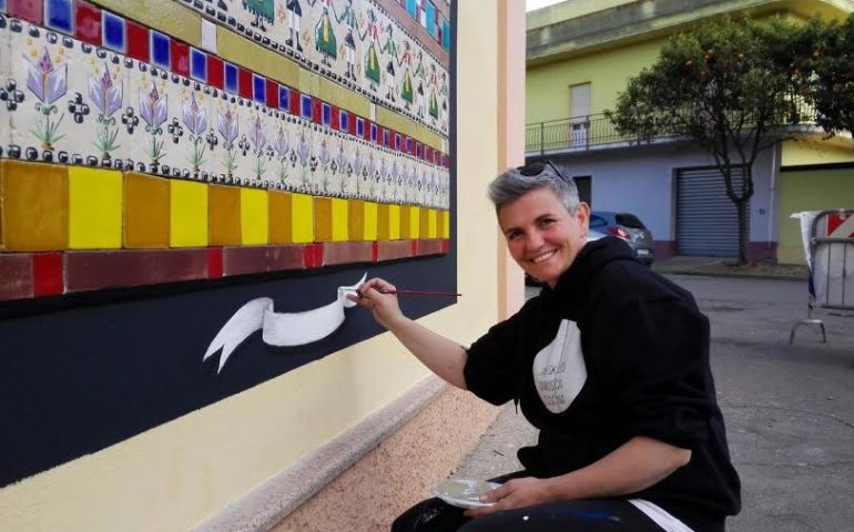 Claudia Filigheddu firma il nuovo murale di San Gavino con il suo iconico e coloratissimo arazzo