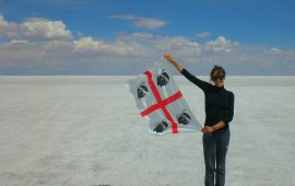 La foto ritrae Claudia Tavani, blogger, durante uno dei suoi viaggi, mentre mostra la bandiera dei quattro mori