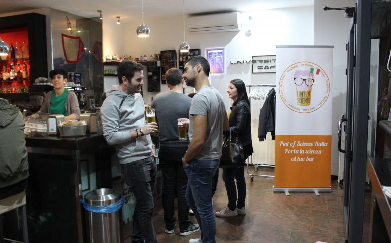 Alcuni ragazzi parlano bevendo una birra all'University Cafe in occasione di Pint of Science