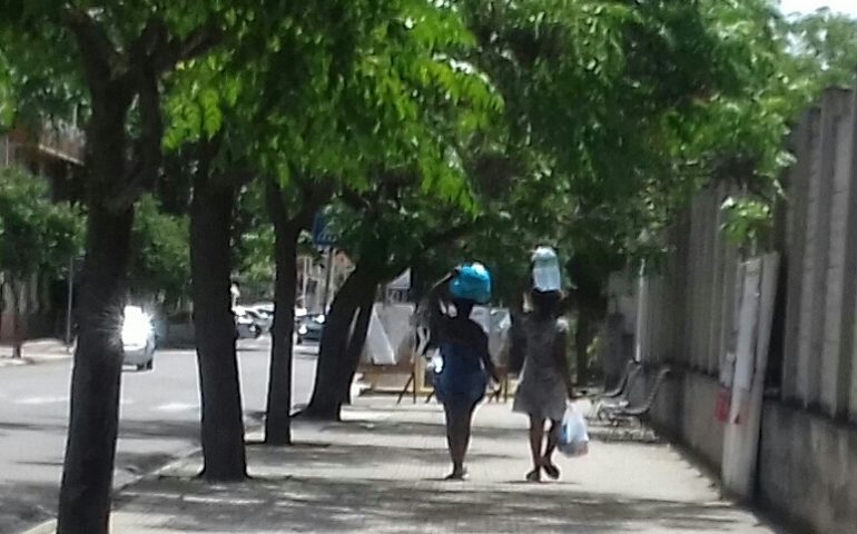 La foto del giorno. Assemini due ragazze portano a casa la spesa sulla testa tra passato e futuro