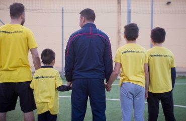 Andrea Cossu con un papà e alcuni bambini nel carcere di Uta - Foto Cagliari Calcio