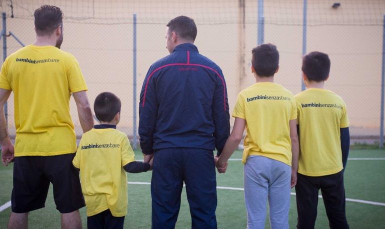 Andrea Cossu con un papà e alcuni bambini nel carcere di Uta - Foto Cagliari Calcio