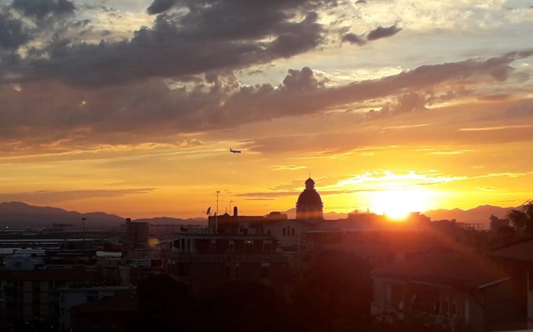 La foto: spettacolare skyline di Cagliari, col sole che tramonta dietro la cupola di Bonaria