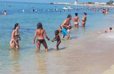 Trapani, le mamme aiutano la figlia della signora che vende in spiaggia, foto da FB