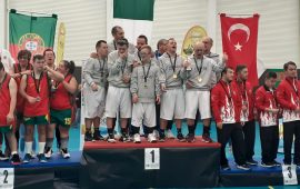 La nazionale italiana di basket con sindrome di Down in una foto di Aurora Basket Cagliari - a sinistra e a destra della coppa gli atleti cagliaritani Davide Paulis e Antonello Spiga