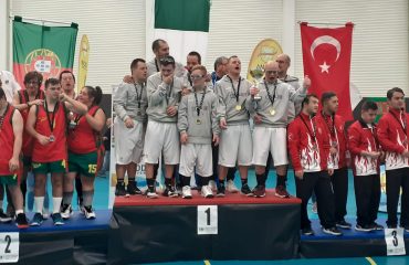 La nazionale italiana di basket con sindrome di Down in una foto di Aurora Basket Cagliari - a sinistra e a destra della coppa gli atleti cagliaritani Davide Paulis e Antonello Spiga