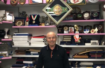 Franco Udella nel suo negozio Udella Sport circondato dai suoi trofei