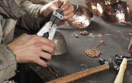 Cropped image of blacksmiths hands working with copper rivets