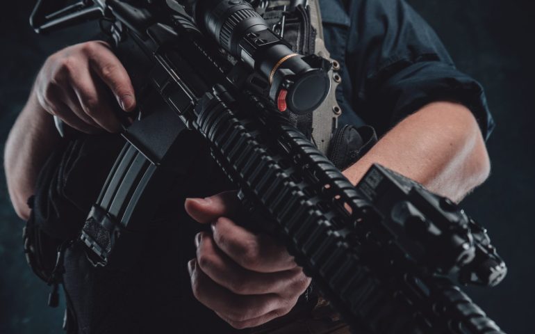 Special forces soldier with contemporary rifle in dark background