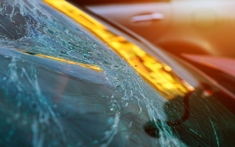 Broken glass on a car with broken windshield after crash accident