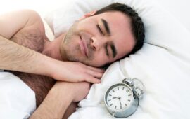 Uomo che dorme con sveglia