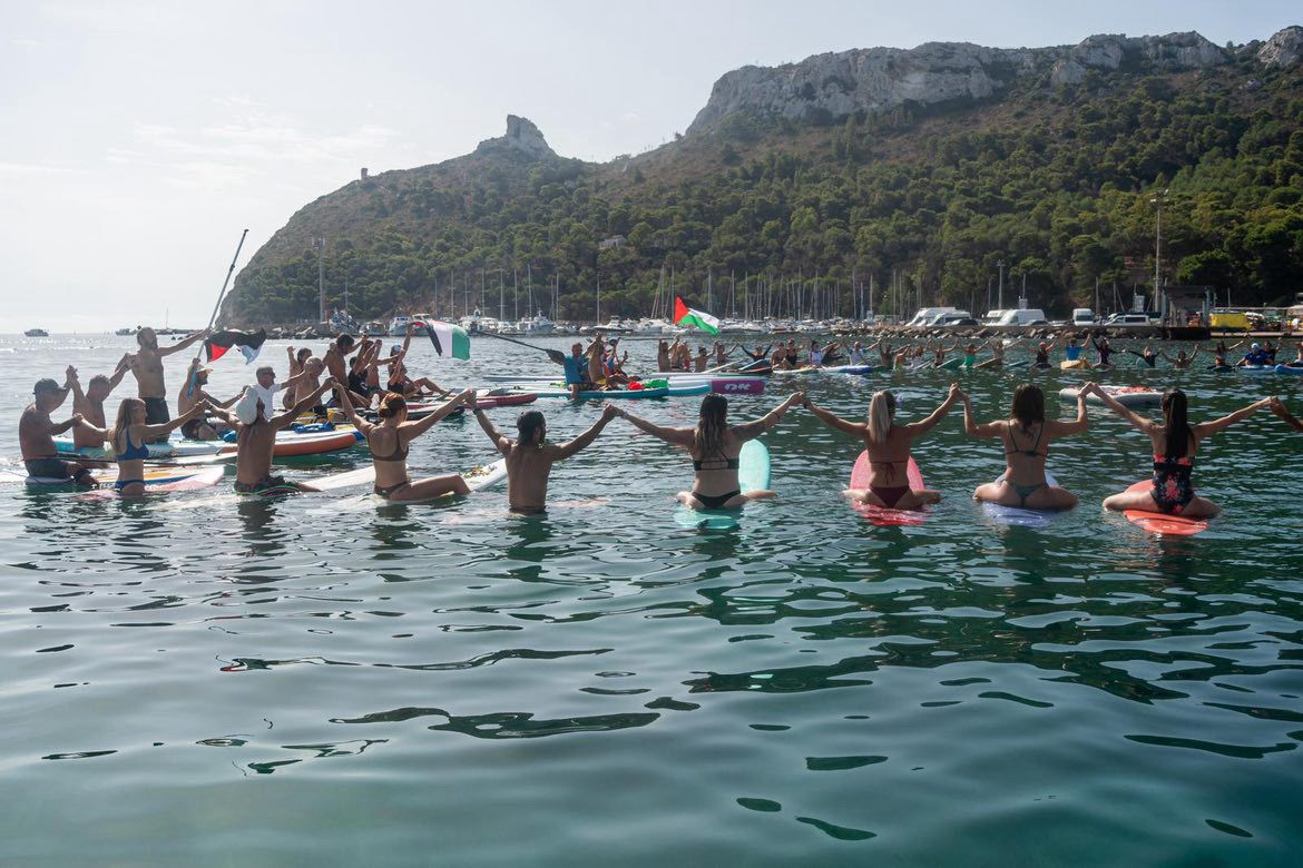 (FOTO) Al Poetto i surfisti cagliaritani hanno dato vita a una spettacolare paddle out per Gaza