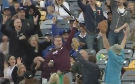 Vola sugli spalti una mazza da baseball: la afferra con una mano, nell’altra tiene una birra (VIDEO)