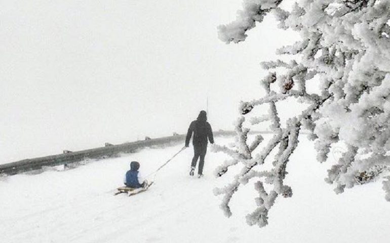 Sardegna sotto la neve. Un bimbo gioca felice con il suo papà sul Bruncu Spina, Fonni