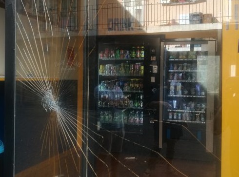 Vandalismo in pieno centro a Nuoro: quattro giovani spaccano la vetrina di un distributore di bibite e fuggono