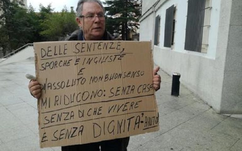 “Senza casa, senza di che vivere e senza dignità”: vogliono demolire la sua abitazione, si apposta armato di cartello di fronte al Tribunale