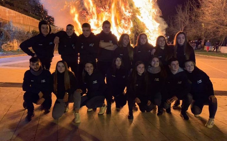 Baunei, i ragazzi del comitato in posa di fronte al fuoco che scoppietta in onore di Sant’Antonio Abate