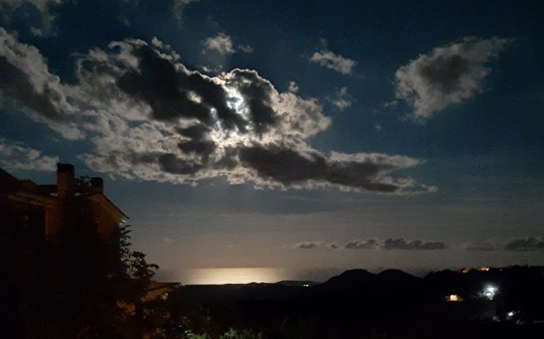 Le foto dei lettori. Ad Arzana la luna dietro le nuvole si specchia sul mare