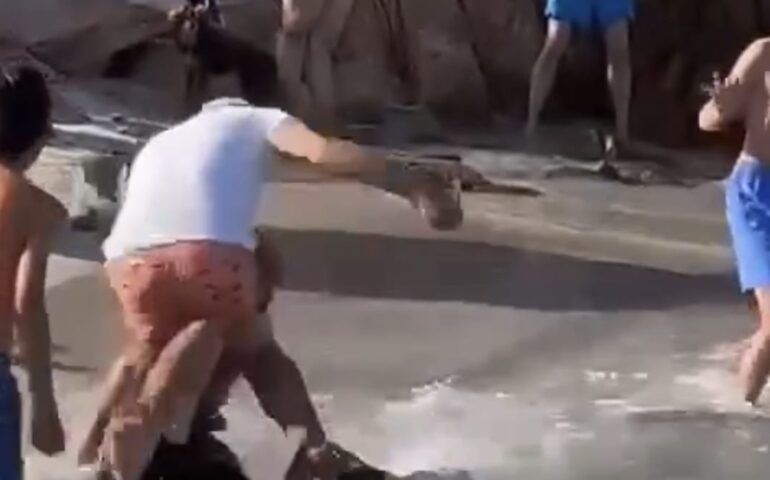 (VIDEO) Gommone di turisti arriva in spiaggia sulla riva, parte un calcio volante di un bagnante infuriato