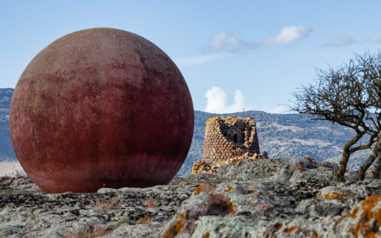 (FOTO) Cosa ci fanno tre grosse sfere di cemento accanto a un nuraghe? L’opera misteriosa visitabile in Sardegna