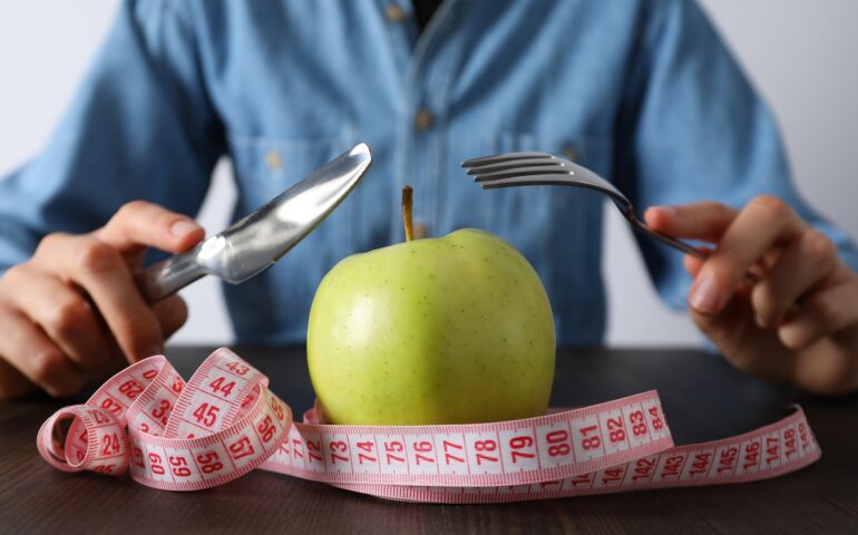 Concept of weight loss and healthy nutrition with apple and meas