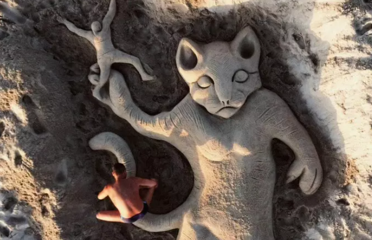 Gattino giù dal ponte: una scultura di sabbia in spiaggia per sensibilizzare contro i maltrattamenti