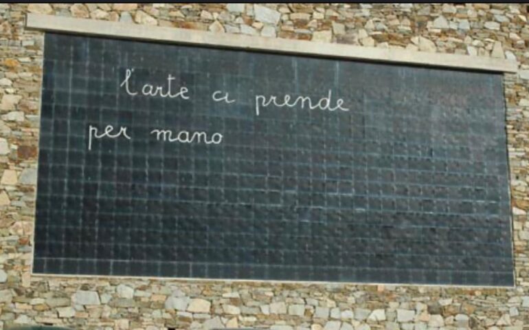 In Sardegna esiste un’enorme lavagna scolastica sul muro di un paese: dove ci troviamo?