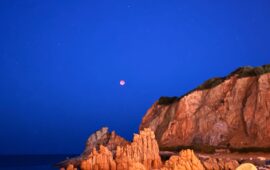 La foto. Arbatax, l’eclissi di luna incornicia le Rocce Rosse